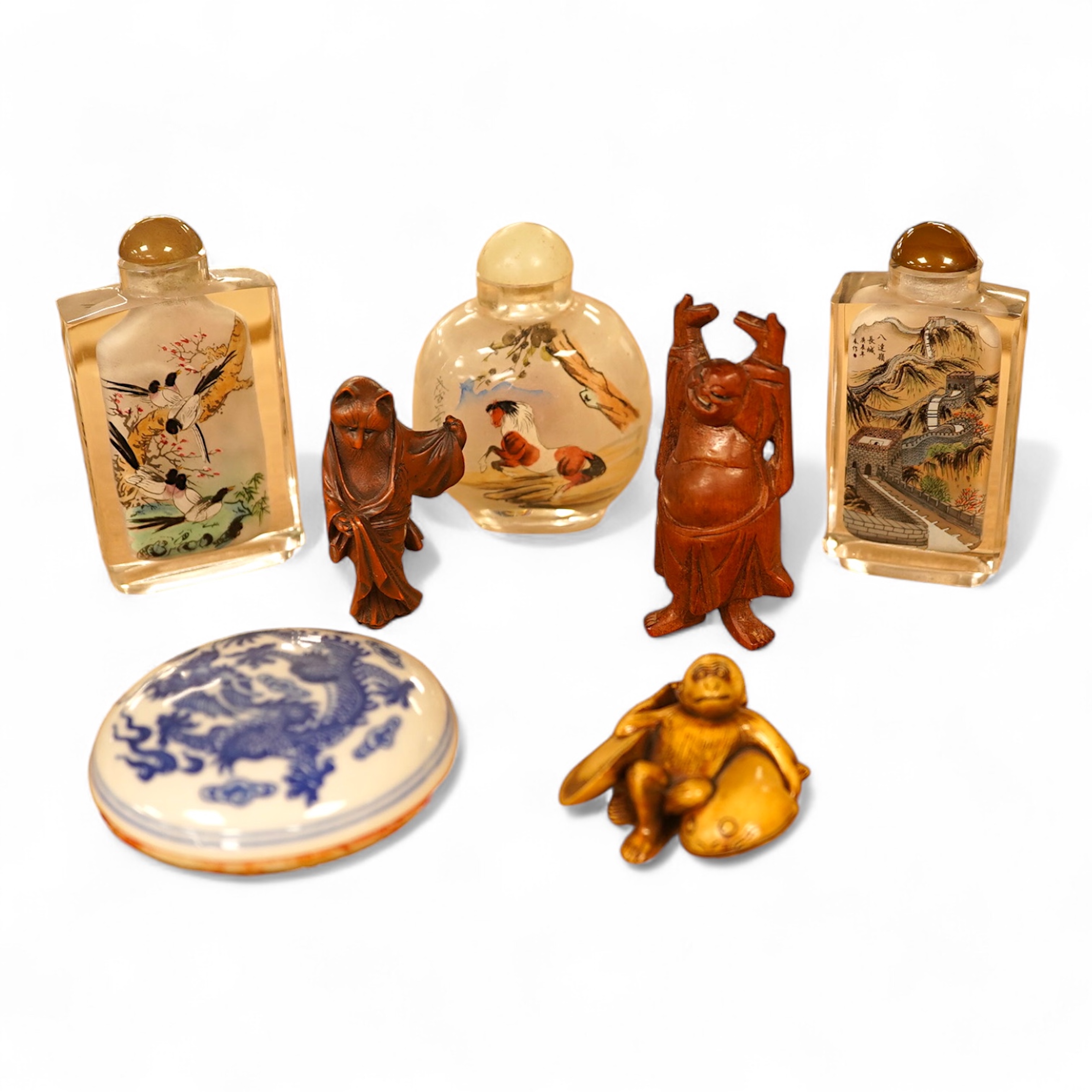 A collection of Chinese and Japanese items comprising snuff bottles, blue and white seal box and netsukes, largest 9cm high